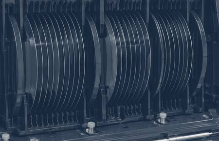 Looking into an open wafer carrier: the edges of silicon wafers held in evenly spaced slots, seen as a stack of fine parallel lines.