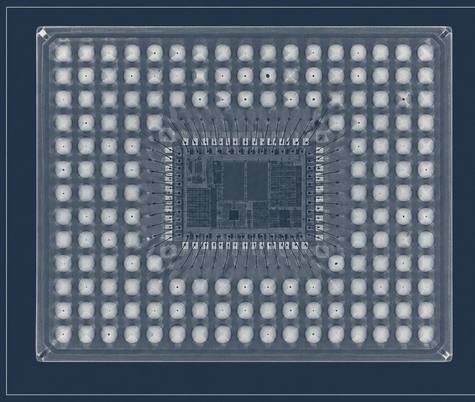 An X-ray radiograph looking through a ball grid array package: a regular grid of solder joints surrounding the die, with bond wires fanning out from it.